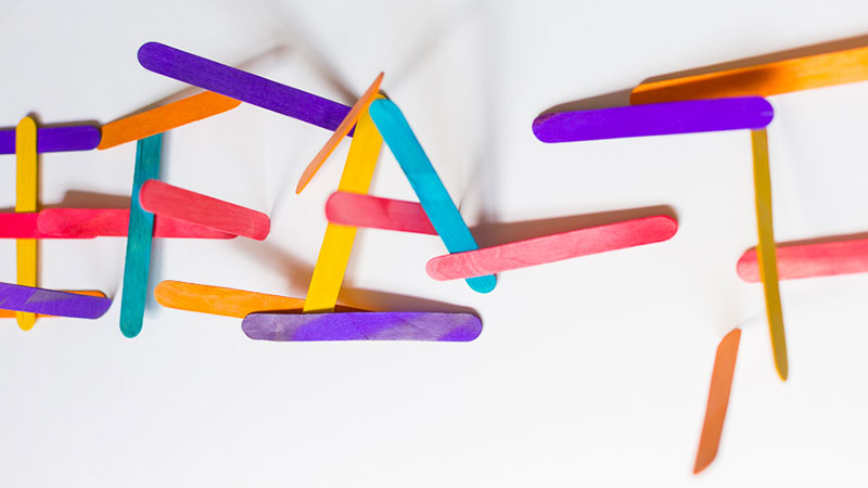 A jumble of colorful popsicle sticks exploding into the air.