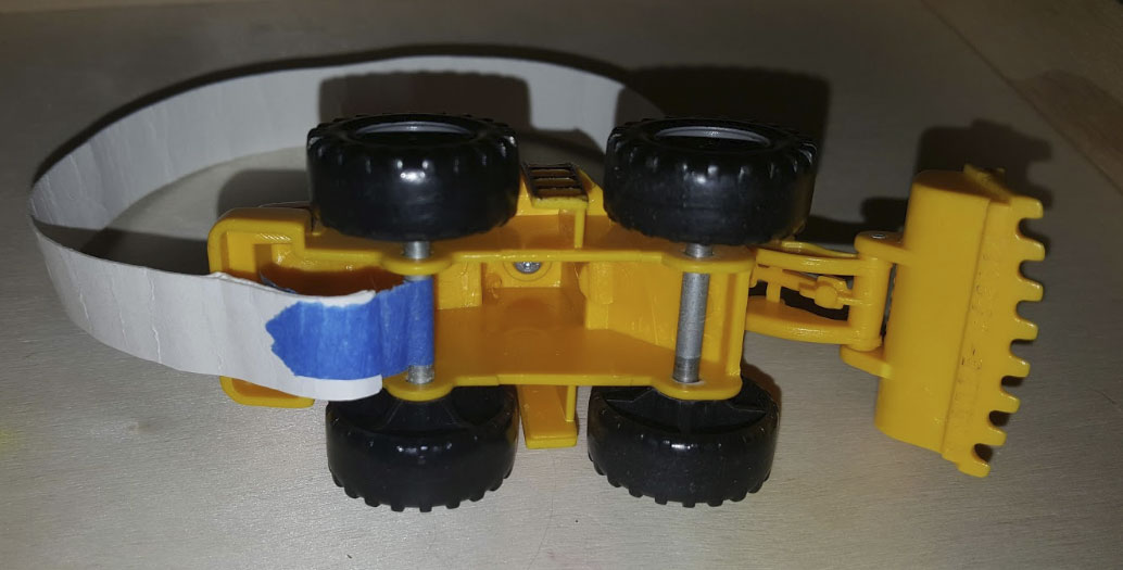 Bottom of a plastic toy digger showing tape around the axle.